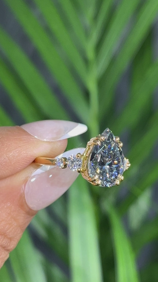 Yellow Gold Pear Shaped Dark Blue Gemstone Ring with Round Accent Stones